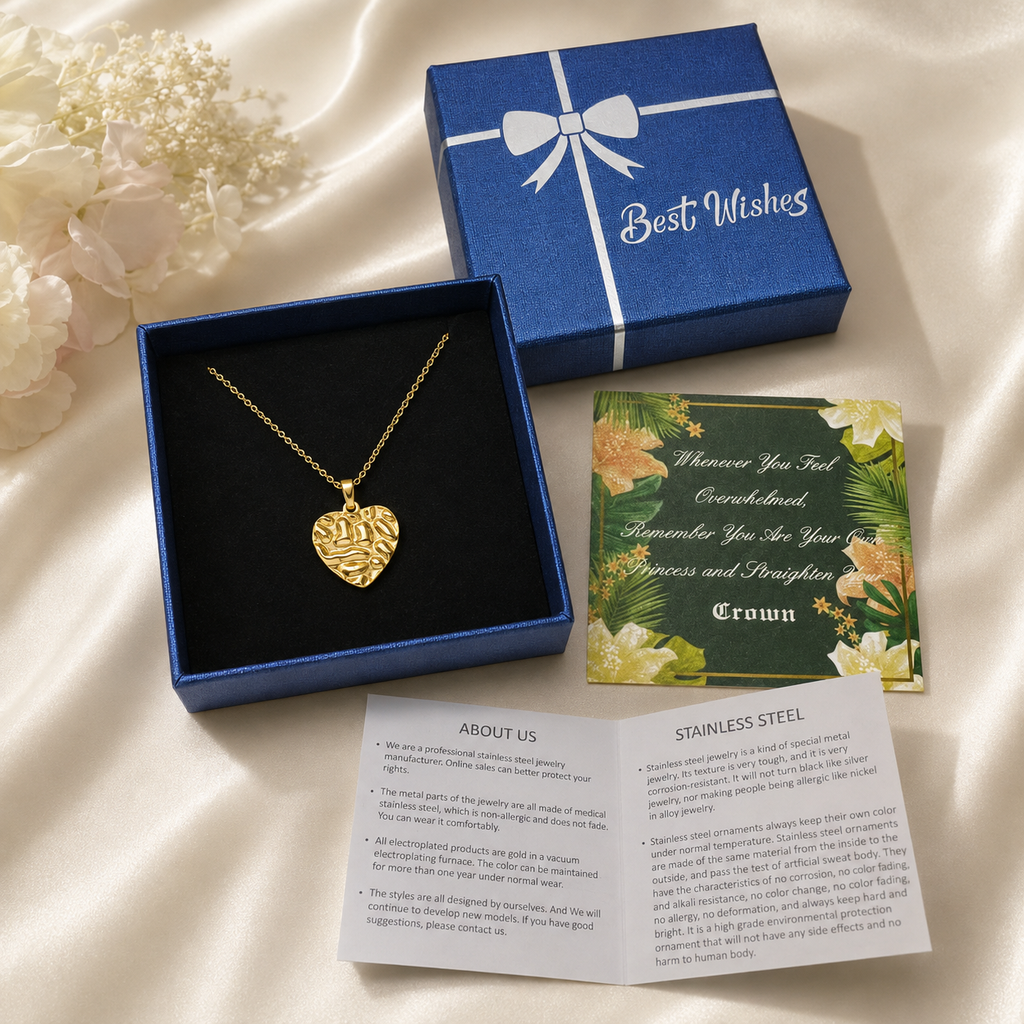 Gold necklace gift box package with a textured heart pendant in blue box, floral message card, and care guide.
