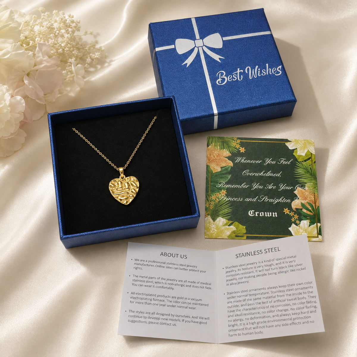 Gold necklace gift box package with a textured heart pendant in blue box, floral message card, and care guide.