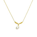 Gold antler pearl pendant necklace close-up on white background — antler charm with dangling white pearl, fine gold chain